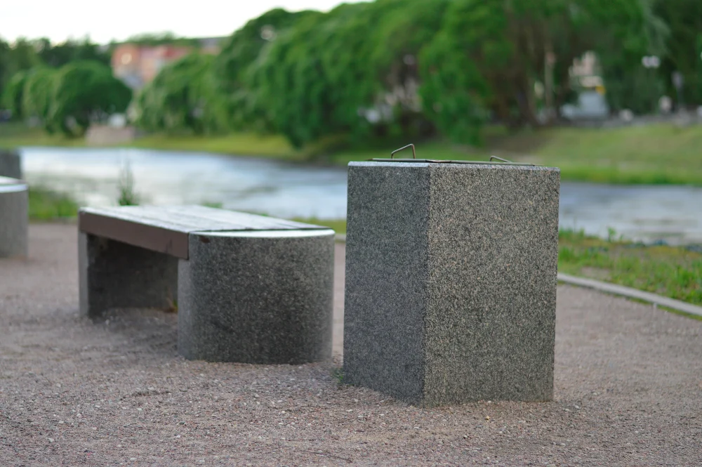 Repurposed concrete hollow blocks designed as sleek, industrial outdoor seating along a scenic riverwalk.